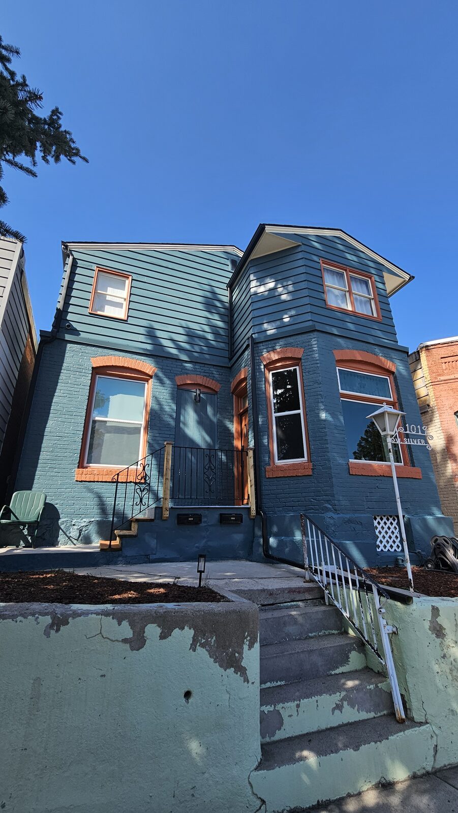 Restored Victorian home with deep blue siding and copper-toned trim