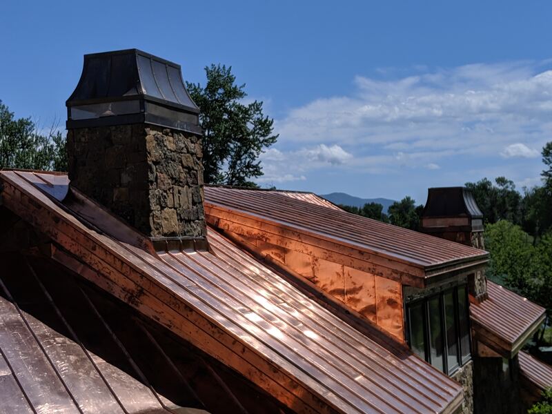 Copper standing-seam roof with stone chimney